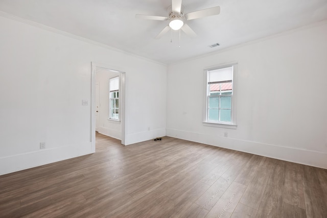 empty room with ceiling fan, ornamental molding, and wood-type flooring