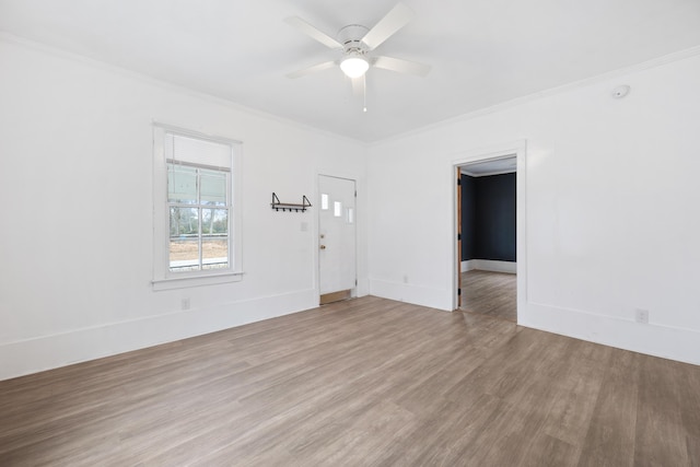 empty room with ornamental molding, ceiling fan, and light hardwood / wood-style flooring