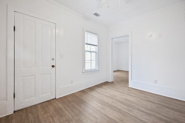 empty room featuring ceiling fan, ornamental molding, and light hardwood / wood-style floors