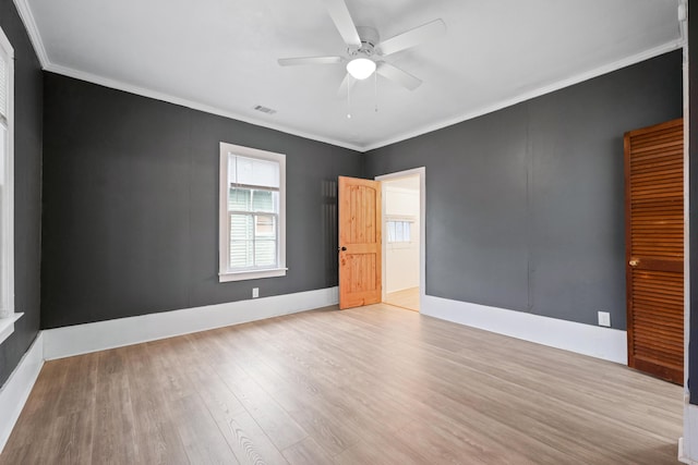 empty room with ceiling fan, ornamental molding, and light hardwood / wood-style floors