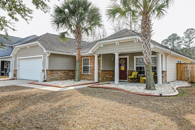 view of front of home featuring a shingled roof, concrete driveway, fence, and an attached garage