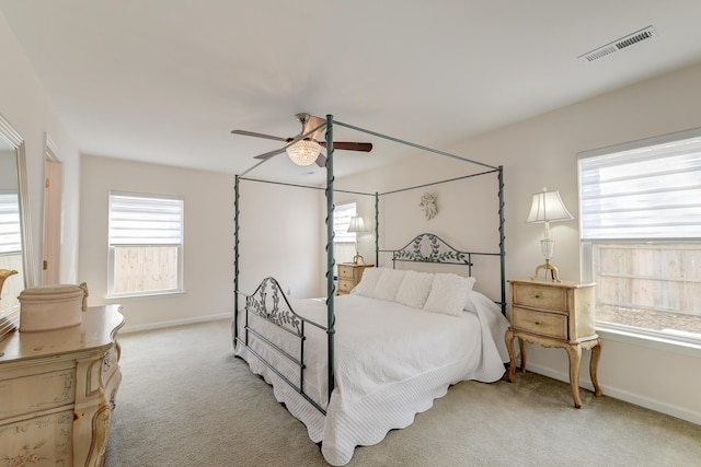 bedroom featuring light carpet, baseboards, visible vents, and a ceiling fan