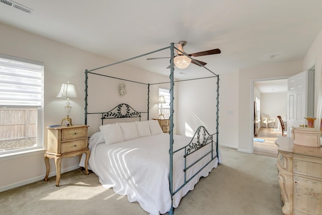 bedroom featuring light carpet, baseboards, visible vents, and a ceiling fan