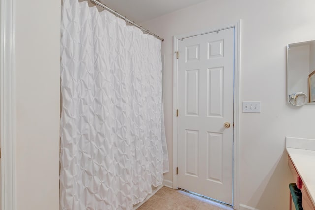 bathroom with tile patterned flooring, vanity, and curtained shower