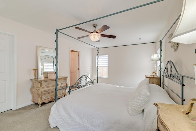 bedroom with light colored carpet, ceiling fan, and baseboards