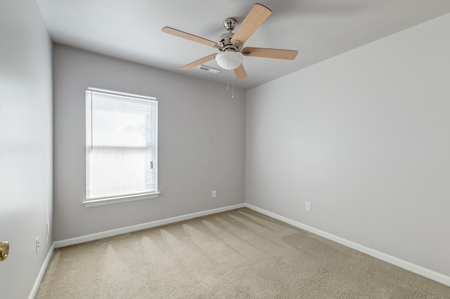 spare room featuring ceiling fan, carpet, visible vents, and baseboards