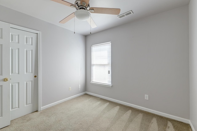 unfurnished bedroom with carpet floors, visible vents, baseboards, and a ceiling fan