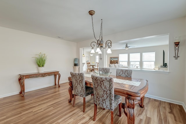 dining space with light wood-type flooring, visible vents, and baseboards