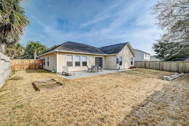 back of property with a patio area, a yard, and a fenced backyard