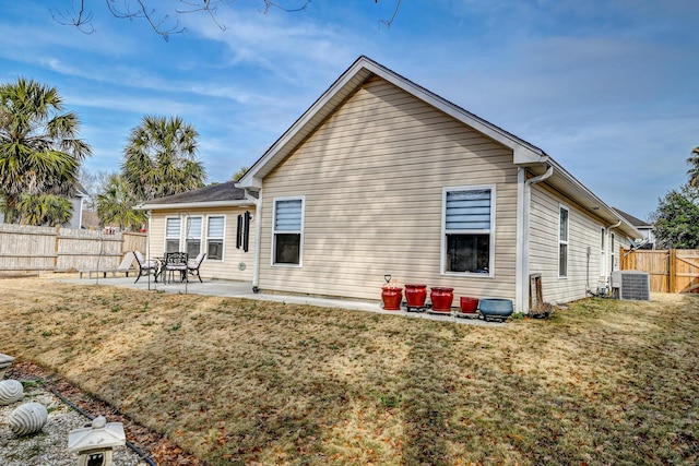 back of house with central air condition unit, a fenced backyard, a lawn, and a patio