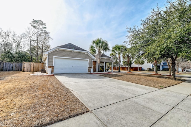 ranch-style house with driveway, stone siding, an attached garage, and fence