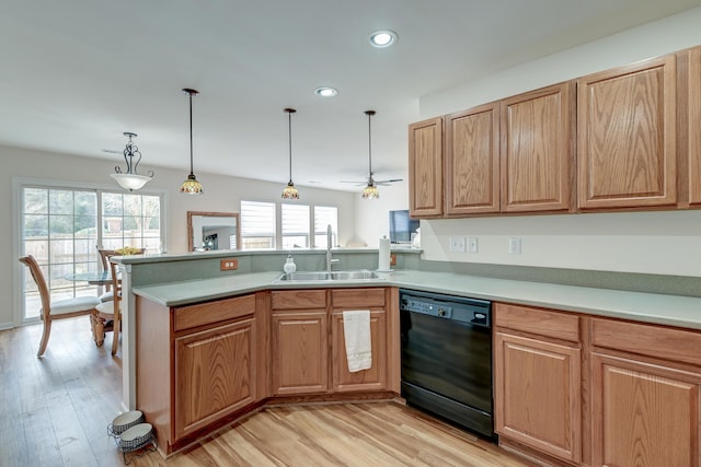 kitchen with light countertops, light wood-style flooring, a sink, dishwasher, and a peninsula