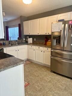 kitchen featuring stainless steel fridge with ice dispenser, white cabinetry, and sink