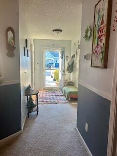 hallway with carpet floors and a textured ceiling