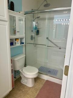 bathroom featuring toilet and walk in shower