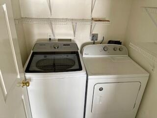 clothes washing area with washing machine and dryer