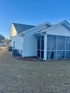 view of home's exterior featuring cooling unit, a sunroom, and a lawn