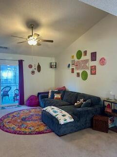 carpeted living room featuring ceiling fan and vaulted ceiling