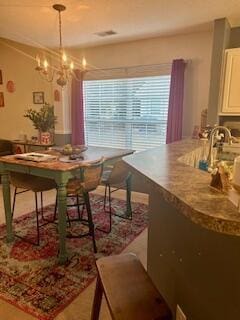 dining room with a notable chandelier and sink