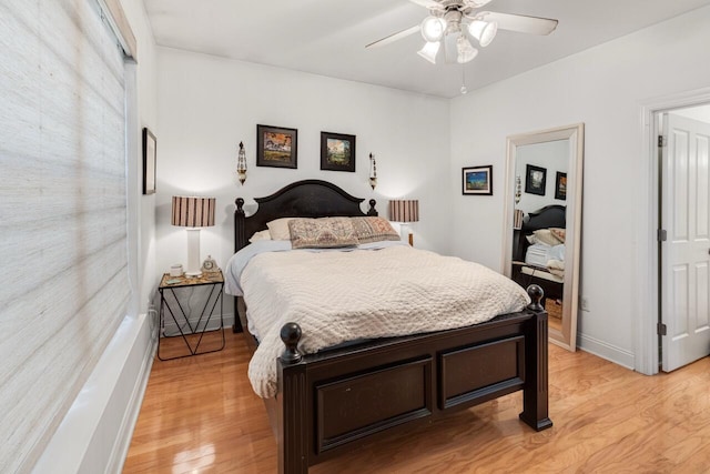 bedroom with light wood-style flooring, a ceiling fan, and baseboards