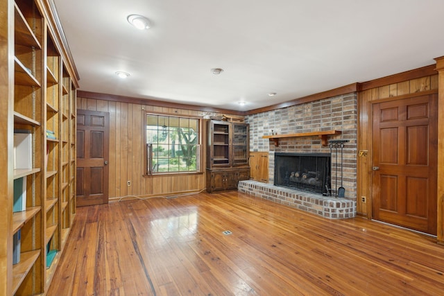 810 Creekside Dr, Mount Pleasant, SC 29464 - unfurnished living room with wooden walls, a brick fireplace, and wood-type flooring