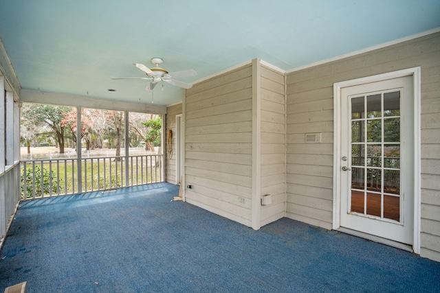 unfurnished sunroom featuring ceiling fan