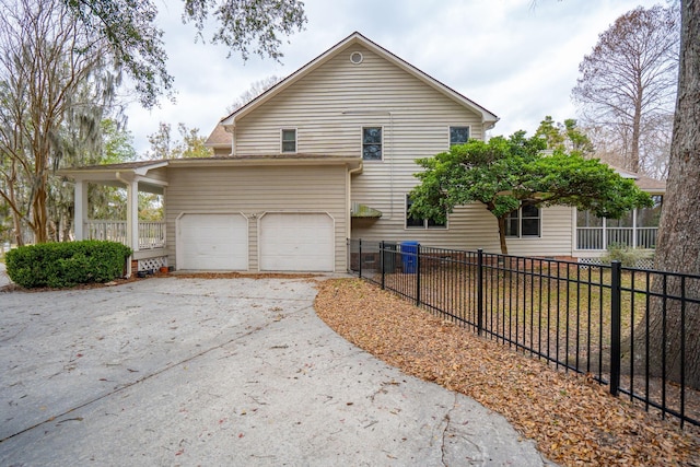 view of property exterior with driveway and fence