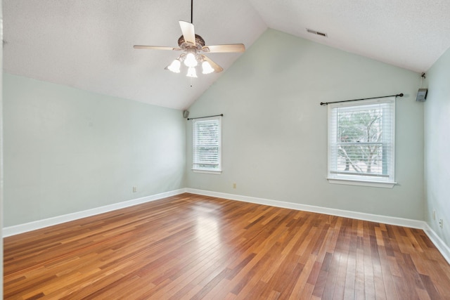 spare room with visible vents, ceiling fan, hardwood / wood-style flooring, and baseboards