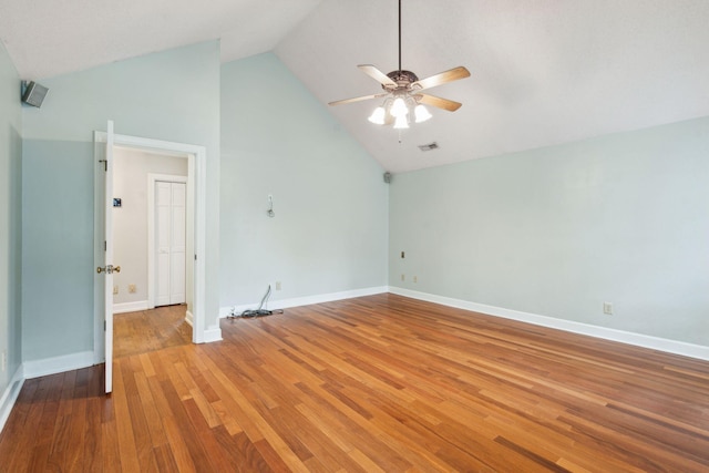 spare room featuring high vaulted ceiling, wood finished floors, a ceiling fan, and baseboards