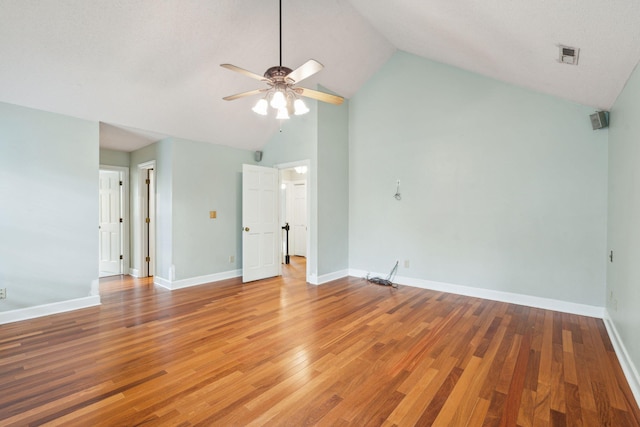 interior space with ceiling fan, high vaulted ceiling, light wood-style flooring, visible vents, and baseboards