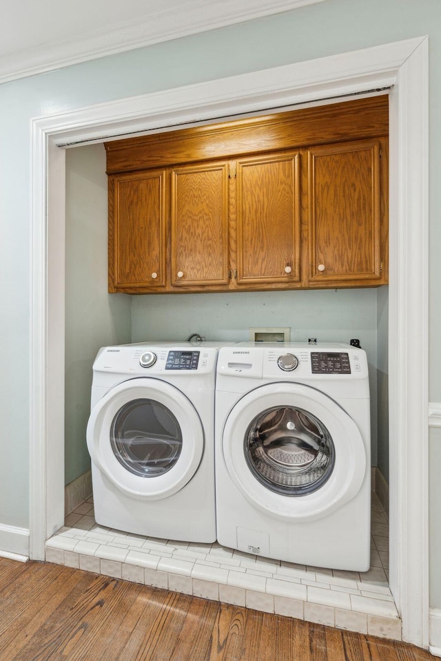 laundry room featuring baseboards, independent washer and dryer, cabinet space, and crown molding