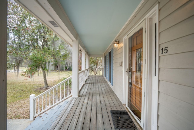 wooden terrace with visible vents and a porch