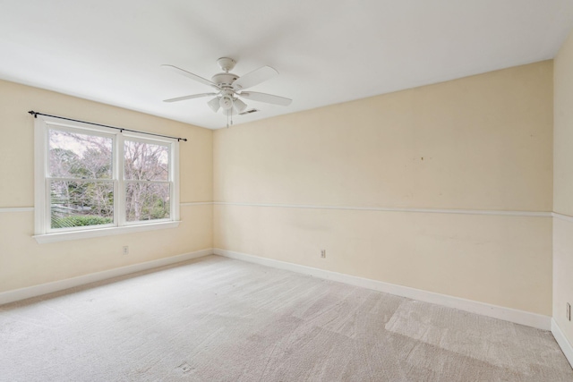 carpeted empty room with a ceiling fan, visible vents, and baseboards