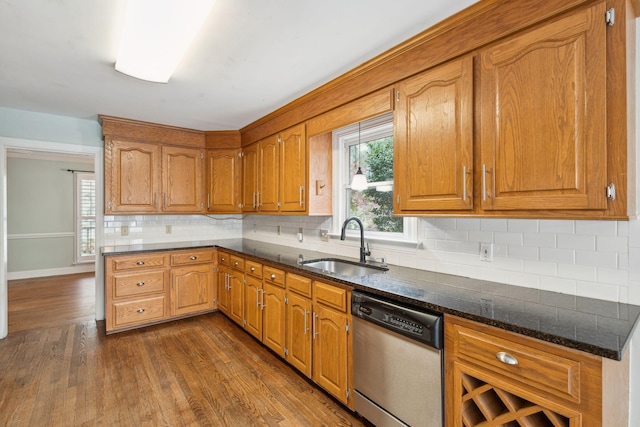 kitchen featuring dark wood-style flooring, brown cabinets, a sink, and stainless steel dishwasher