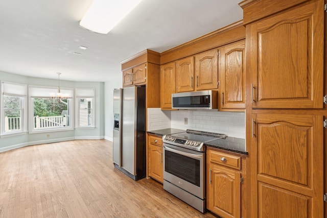 kitchen featuring stainless steel appliances, light wood-type flooring, brown cabinetry, and decorative backsplash