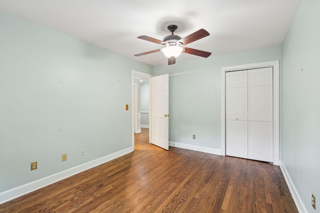 unfurnished bedroom with a closet, wood finished floors, a ceiling fan, and baseboards