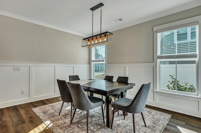 dining room featuring a wainscoted wall, visible vents, dark wood finished floors, and crown molding