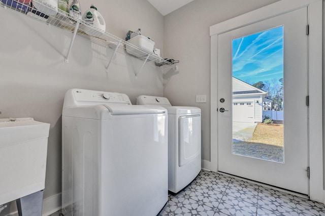 washroom featuring a sink, laundry area, light floors, and washer and dryer