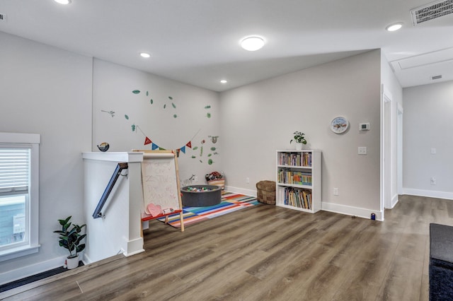 recreation room featuring baseboards, wood finished floors, visible vents, and recessed lighting