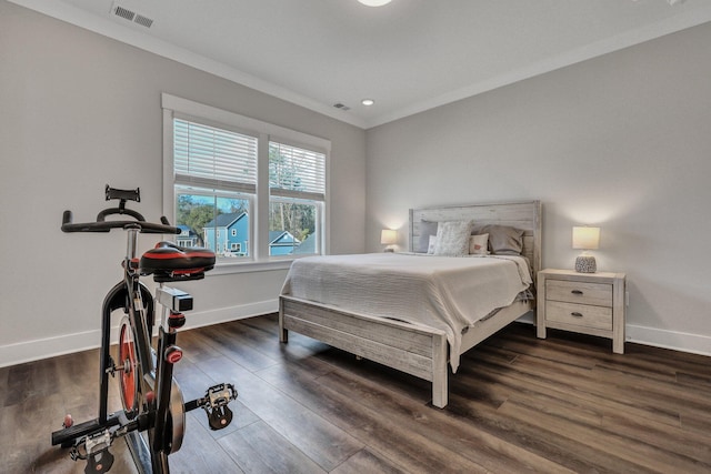 bedroom featuring ornamental molding, wood finished floors, visible vents, and baseboards