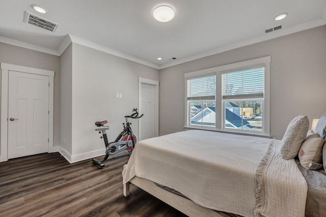 bedroom with ornamental molding, dark wood-style flooring, visible vents, and baseboards