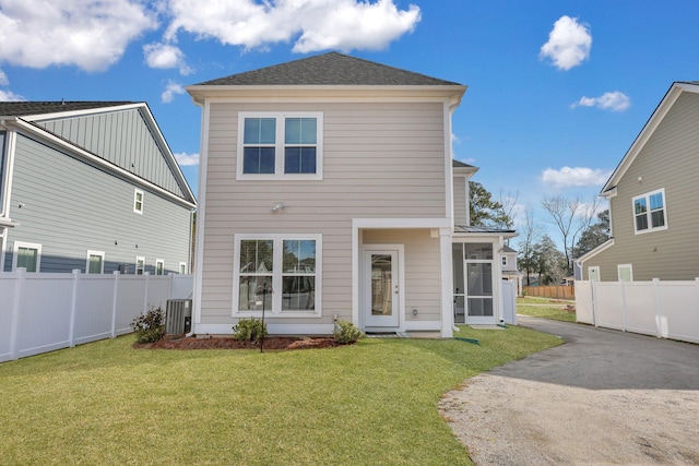 rear view of house with a yard, fence, a sunroom, and central air condition unit