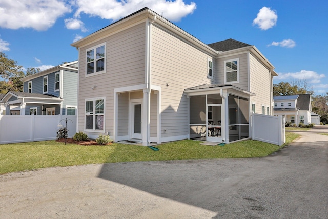 back of house with a yard, fence, and a sunroom