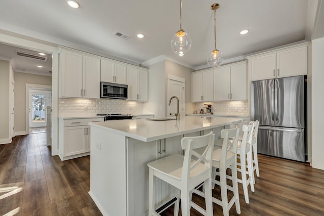 kitchen featuring appliances with stainless steel finishes, visible vents, a sink, and white cabinetry