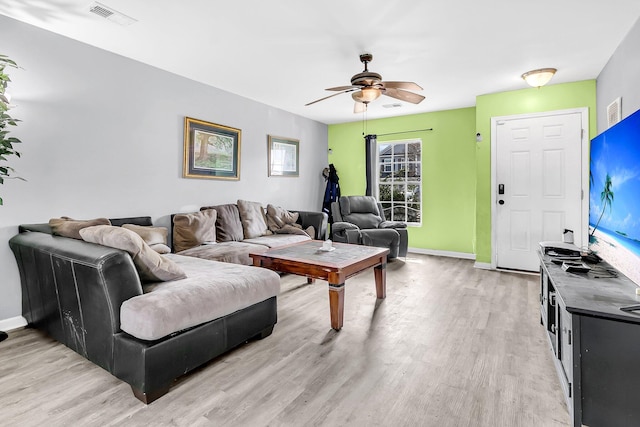 living area featuring light wood-style floors, visible vents, a ceiling fan, and baseboards