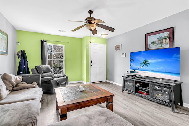 living room with wood finished floors, baseboards, a ceiling fan, and visible vents