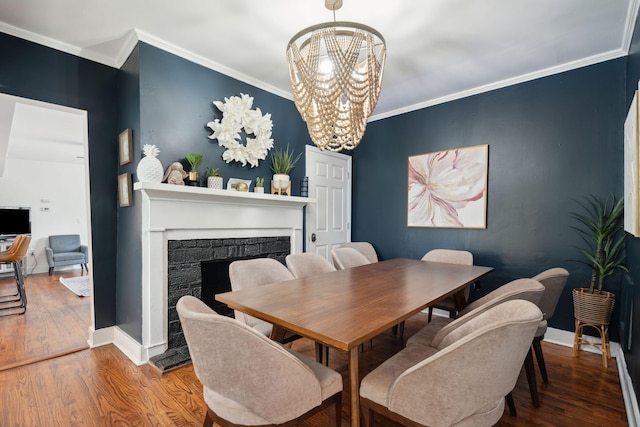 167 Coming St, Charleston, SC 29403 - dining space with a chandelier, wood finished floors, a fireplace, ornamental molding, and baseboards