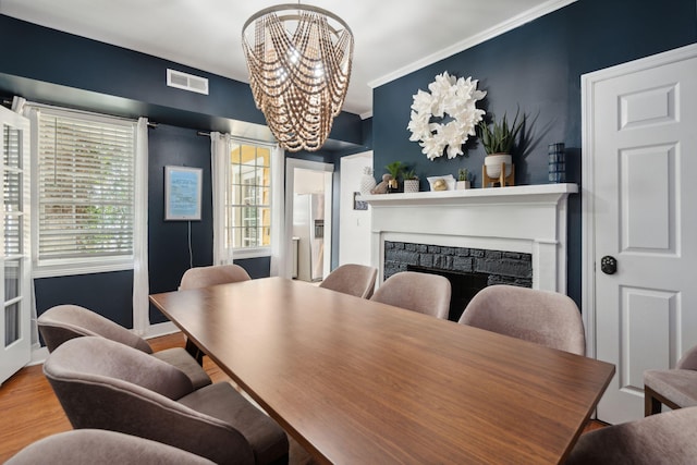 167 Coming St, Charleston, SC 29403 - dining room featuring a chandelier, a fireplace, wood finished floors, and ornamental molding