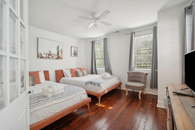 bedroom with dark wood finished floors, visible vents, baseboards, and ceiling fan