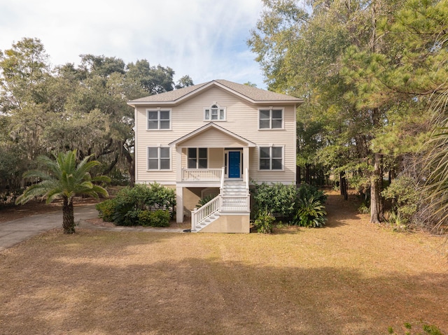 view of front of house with covered porch and a front lawn